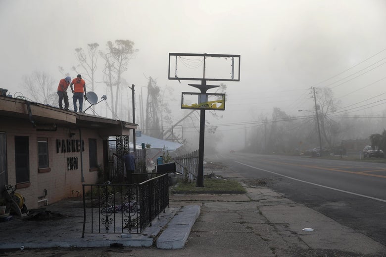 Workers on the roof of a hurricane-damaged hotel.